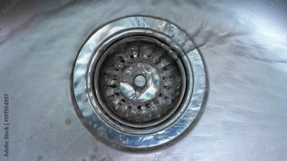 Streaming water in sink. Water stream going down the drain.
Streaming water in sink. Water stream going down the drain.