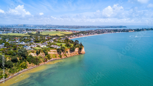 Aerial view on residential suburb on the top of rocky cliff, facing sunny harbour. Auckland, New Zealand. © Dmitri