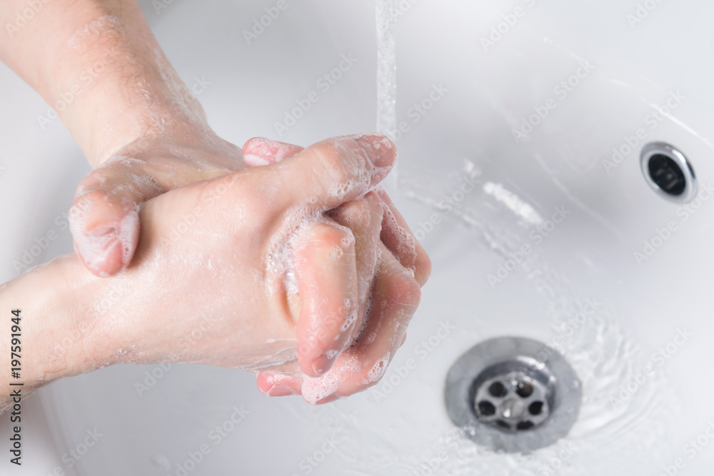 washing hands with soap and water in the bathroom close-up