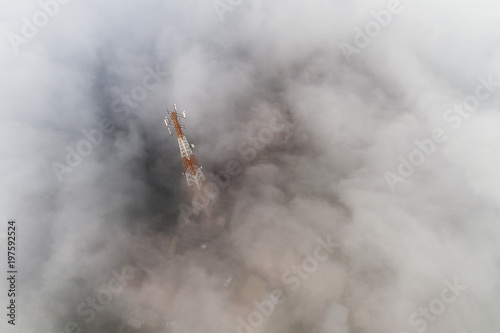 Aerial view of Trees and village houses covered with flowing mist near Bromo volcano at sunset, Indonesia