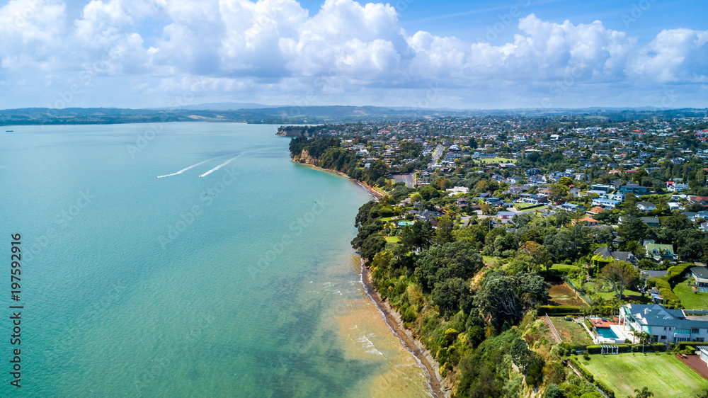 Aerial view on a residential suburb surrounded by beautiful harbor at sunny day. Auckland, New Zealand.