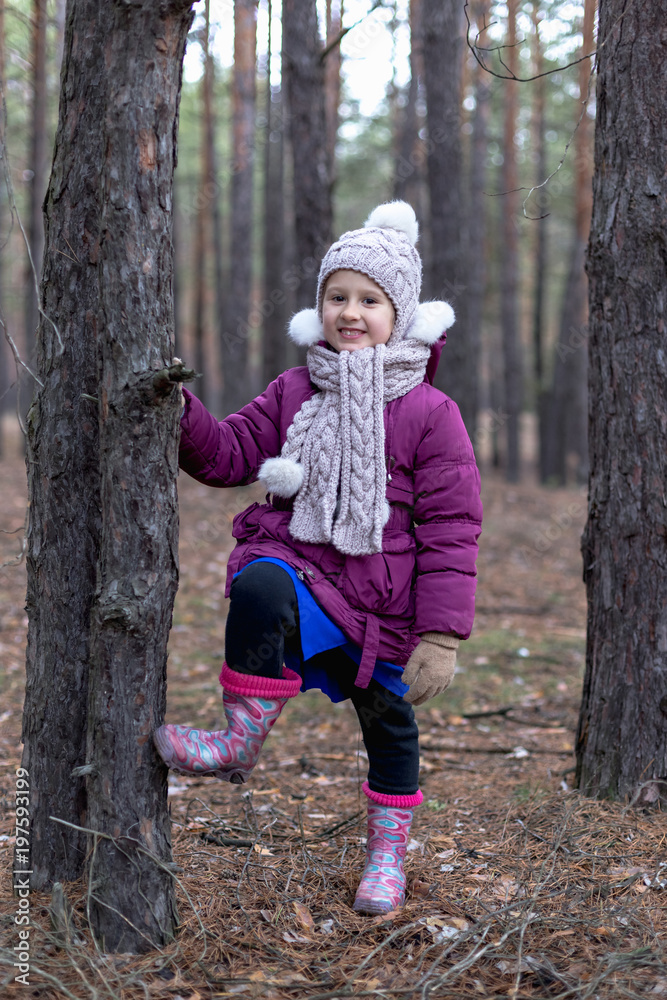 Cute little girl in pine forest in autumn time
