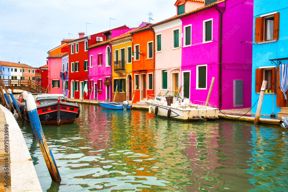 Multicolored walls of houses and motor boats on Burano island, Venice