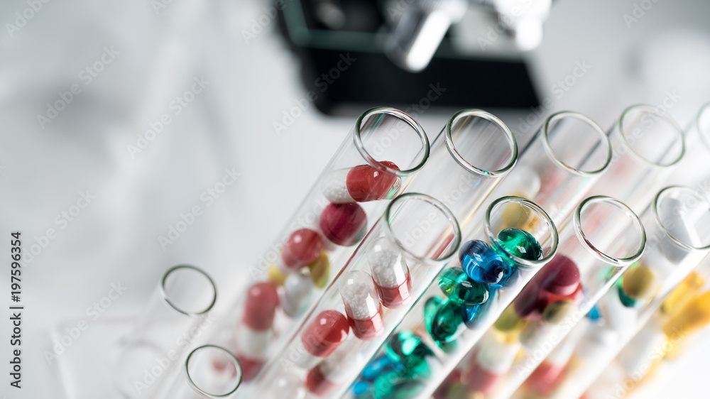 Laboratory Microscope, pills and test tubes. Scientific and healthcare research background. Laboratory Microscope, pills and test tubes. Scientific and healthcare research background.