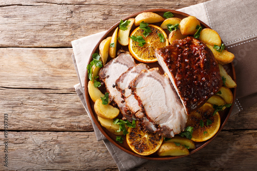 Christmas baked pork with potatoes, oranges and apples. horizontal top view from above