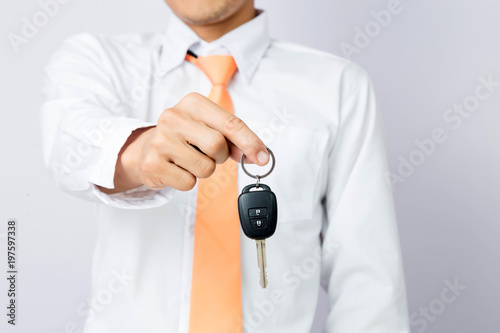 Businessman holding the car key, isolated background
