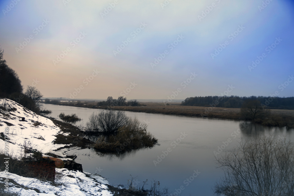 Fototapeta premium small spring river with snow along coast