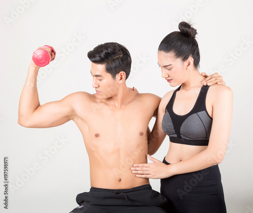 Happy young fitness man and his girlfriend in training time . Fitness and healthy lifestyle concept. Studio shot on white background.