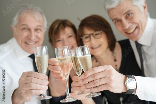 Group of senior people cheering with champagne