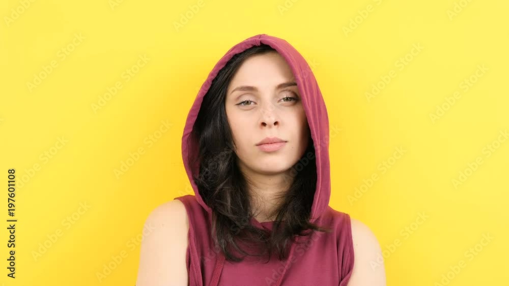 Young woman on yellow background smiling to the camera. Slow motion Young woman on yellow background smiling to the camera. Slow motion