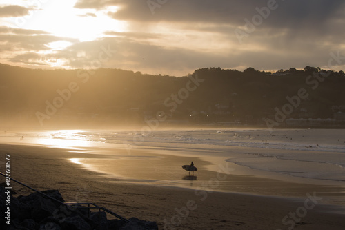 Canvas-taulu silhouette of surfers in scenic golden sunset on hendaye beach, basque country,