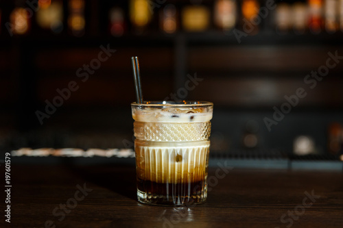A horizontal image of a white russian cocktail in rocks glass in a bar. photo