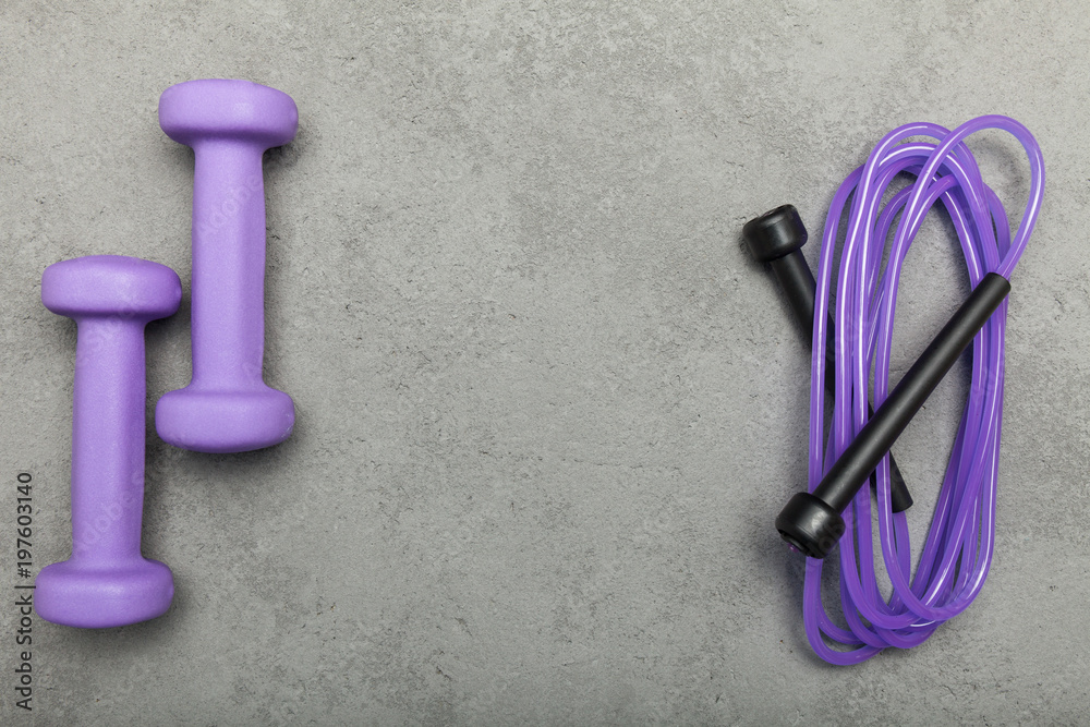 Purple accessories for sports on a gray background. Empty space for text. Purple accessories for sports on a gray background. Empty space for text.