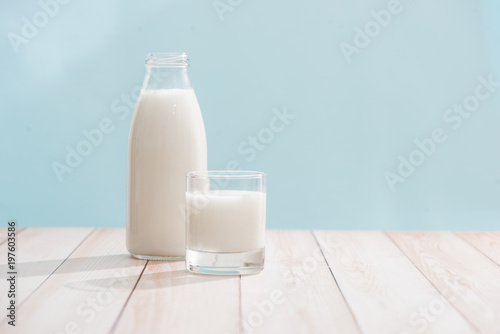 Dairy products. Bottle with milk and glass of milk on wooden table
