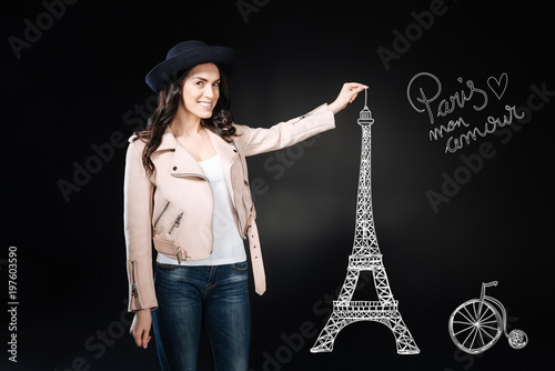 Eifel tower. Cheerful beautiful young woman feeling happy and looking excited while visiting Paris and looking at the Eifel Tower