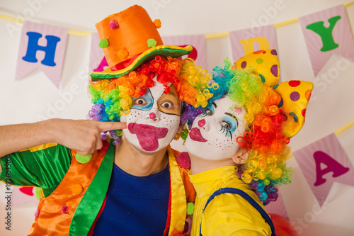 Clowns are a boy and a girl in bright costumes at the child's birthday. The explosion of emotions and the fun of the circus