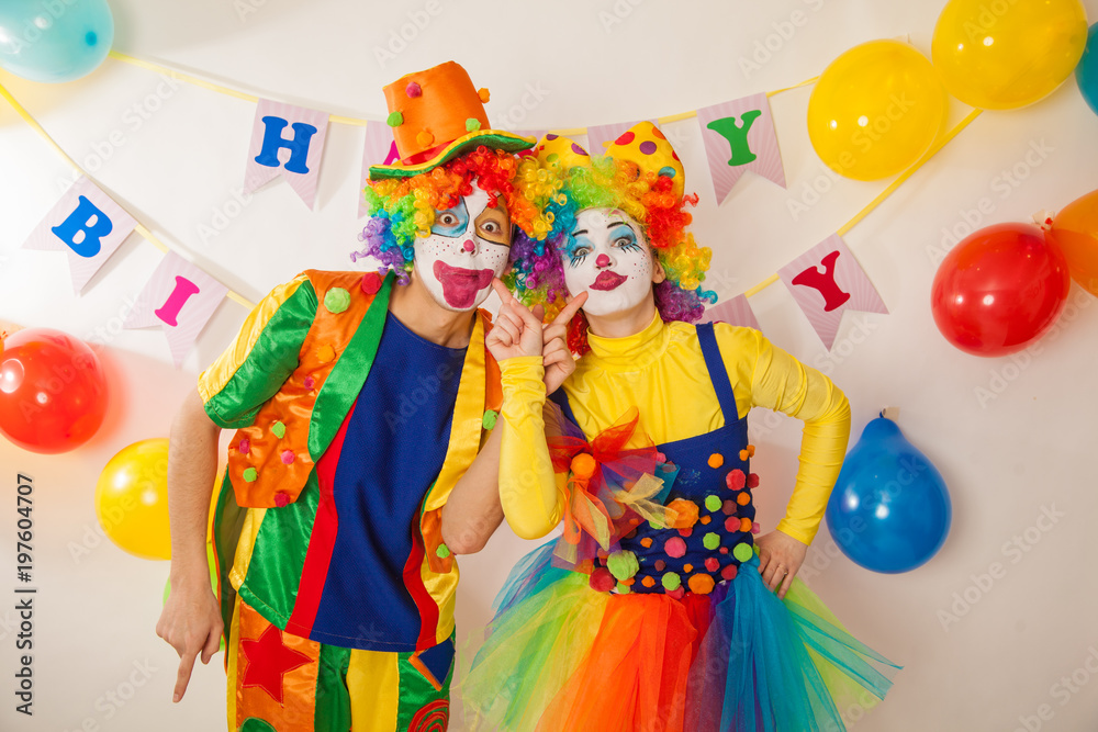 Clowns are a boy and a girl in bright costumes at the child's birthday. The explosion of emotions and the fun of the circus