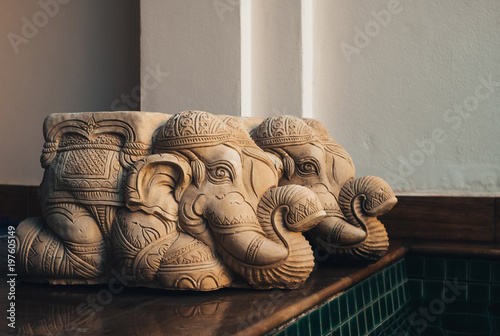 Two Old mortar elephant statue kneeling on the wooden floor inside swimming pool at the home, Vintage