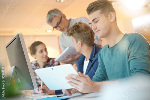 Students in class with teacher working on project