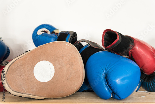 Set of worn boxing and kickboxing accessories: gloves, focus punch pad