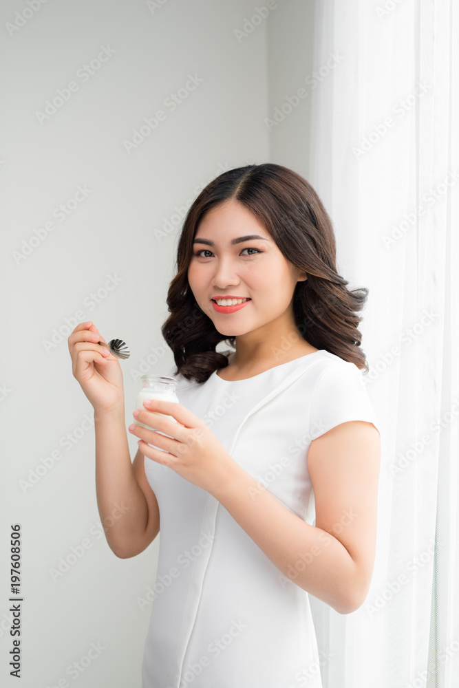 Diet eating / close-up portrait of an attractive young woman eating yogurt Diet eating / close-up portrait of an attractive young woman eating yogurt