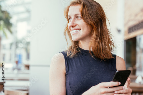 Positive Pretty Lady Using Smartphone Outdoors