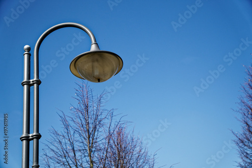 Street lantern in sunny day, turned off, urban background