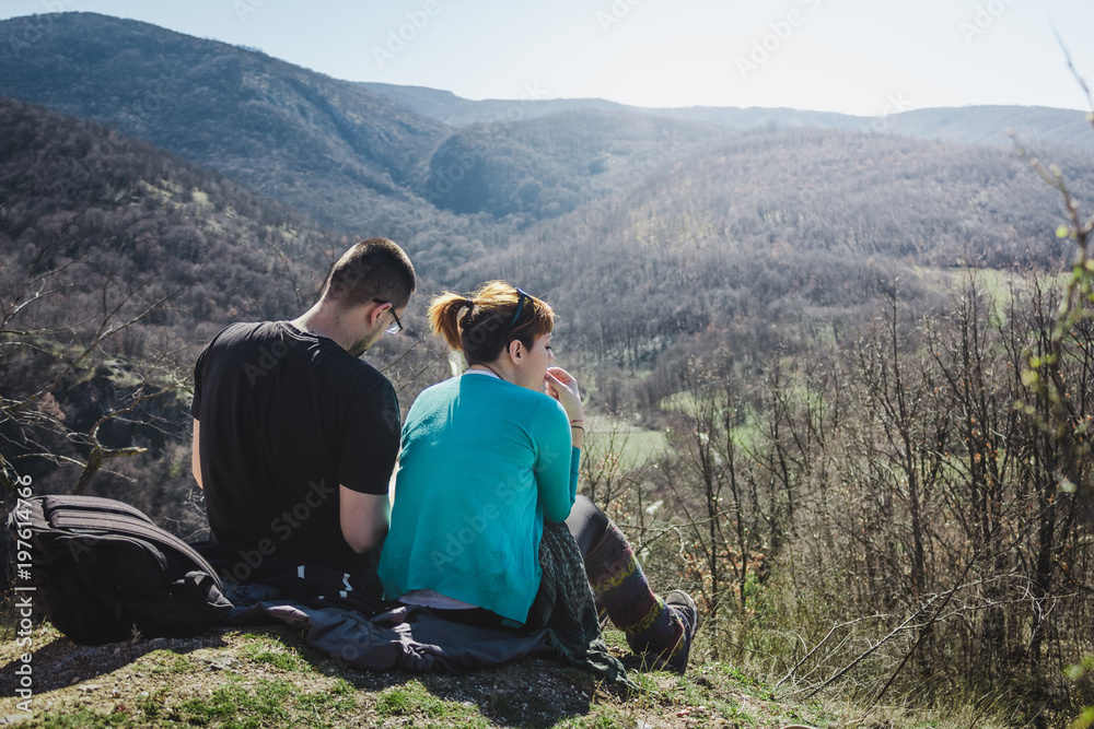 Hikers relaxing on top of a mountain and enjoying sun.