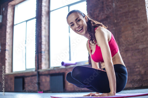 Beautiful smiling woman doing yoga indoors in gym.
