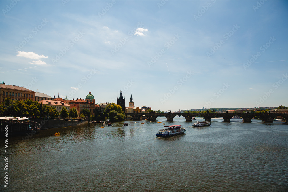 Naklejka premium PRAGUE,CZECH REPUBLIC - JUNE 23, 2017: view of Charles bridge and Vltava river with boats in Prague, Czech Republic