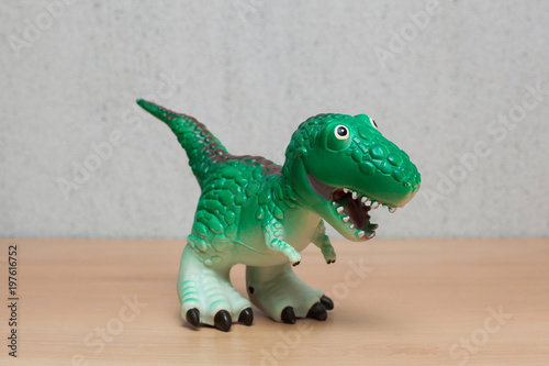 Tyrannosaurus dinosaurs toy on wooden table.