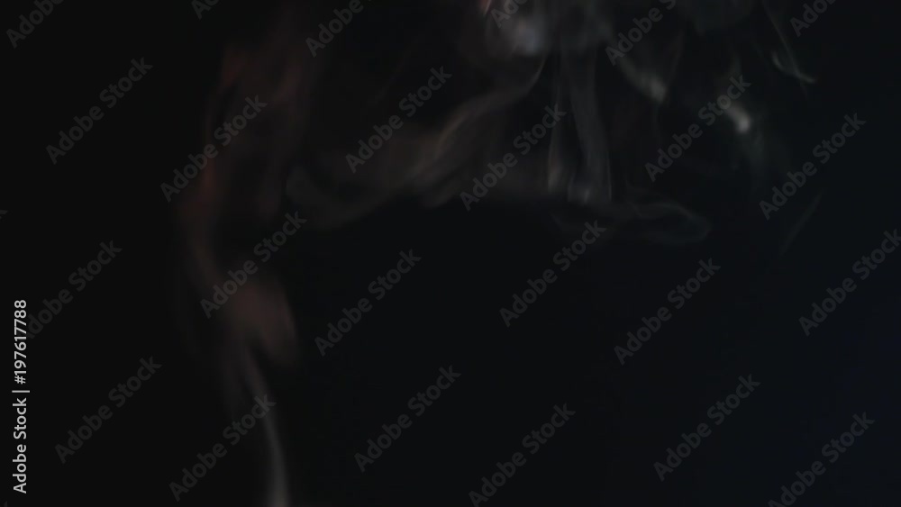 Close up of burning incense sticks with smoke over black background Close up of burning incense sticks with smoke over black background