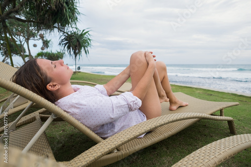 caucasian woman relaxing in chair near indian ocean in Srilanka. Have a good vacation in asia
