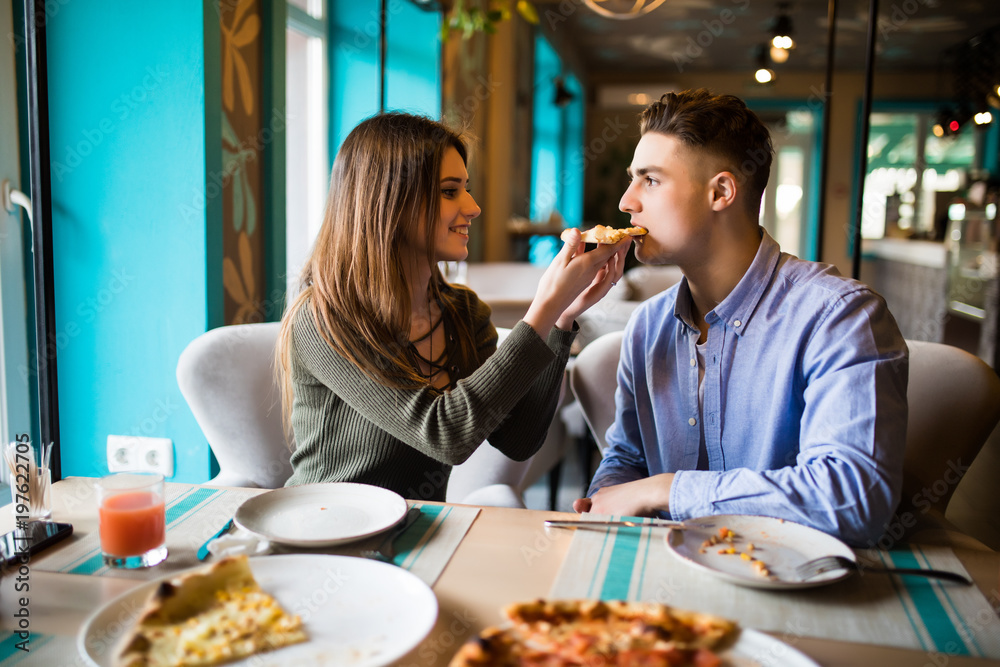 Dating in pizzeria. Handsome smiling couple sharing and enjoying in pizza, having fun together. Dating in pizzeria. Handsome smiling couple sharing and enjoying in pizza, having fun together.