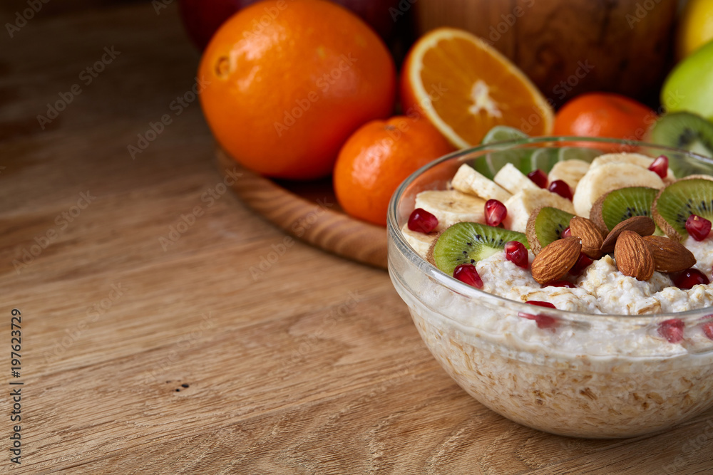 Breakfast still life with oatmeal porridge and fruits, top view, selective focus, shallow depth of field.
