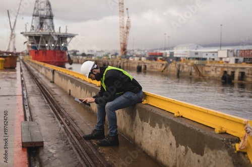 Dock worker using mobile phone photo