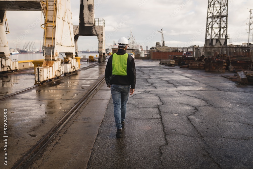 Dock worker walking in the shipyard Dock worker walking in the shipyard