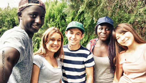 Multi ethnic teenagers smiling outdoor making selfie photo