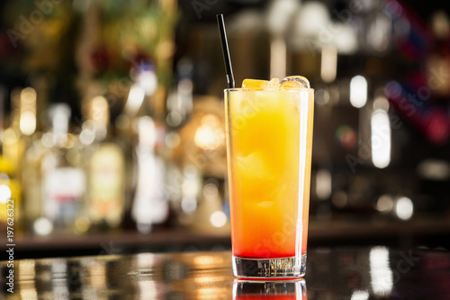 Closeup glass of tequila sunrise cocktail at bar background. photo