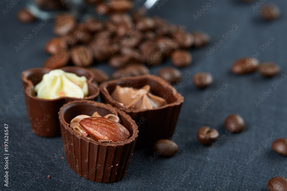 Side view of overturned glass jar with coffee beans and chocolate candies on wooden background, selective focus Side view of overturned glass jar with coffee beans and chocolate candies on wooden background, selective focus