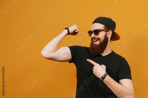 Billede på lærred Playful hipster boasting with biceps