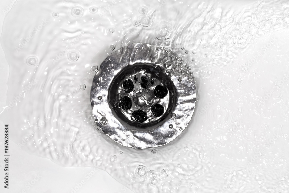 water flows into a sink in a white sink, a close-up photo water flows into a sink in a white sink, a close-up photo