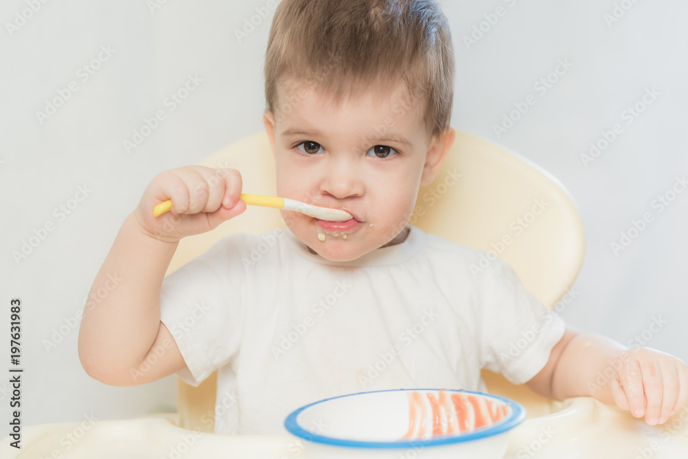baby in the kitchen eating fruit puree baby in the kitchen eating fruit puree