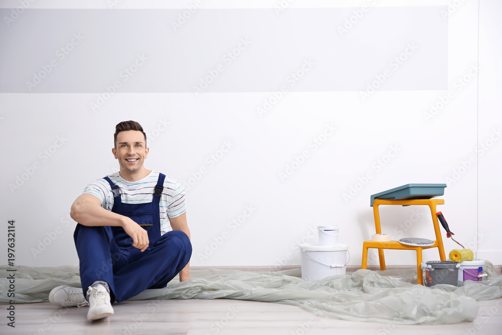 Young male decorator on floor in room