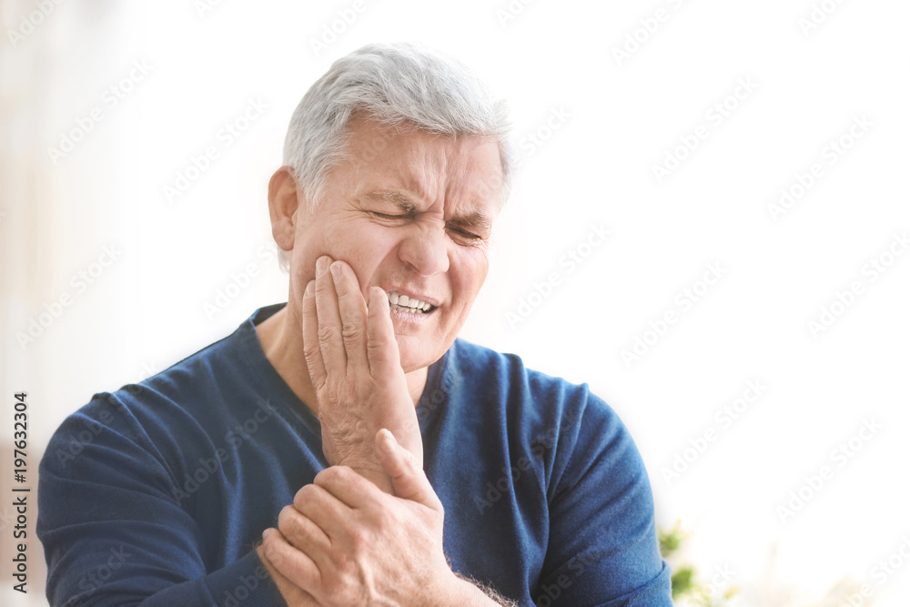 Mature man suffering from toothache at home Mature man suffering from toothache at home