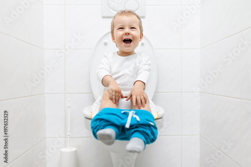 Adorable young child sitting on the toilet