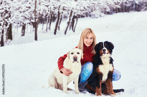 Fototapeta Naklejka Na Ścianę i Meble -  The beautiful woman with dog sitting on the snow