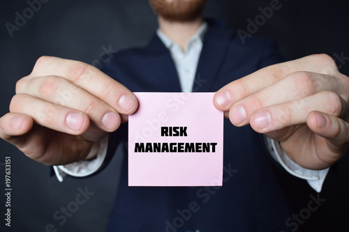 A businessman shows an inscription:RISK MANAGEMENT