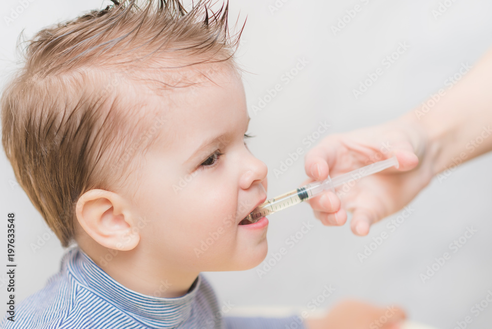 mom gives the baby fish oil through a syringe mom gives the baby fish oil through a syringe