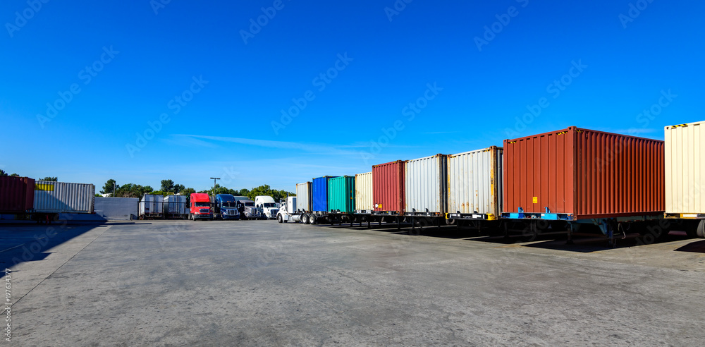 Obraz premium Semi trailers lined up on the ground with blue sky background